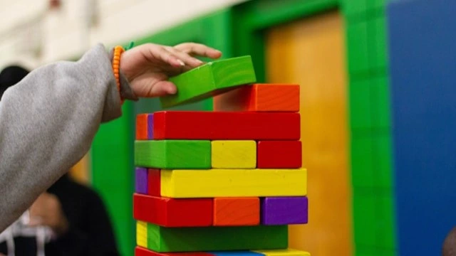 Stacking colorful blocks as a part of cognitive activities for infants to develop problem-solving and fine motor skills.