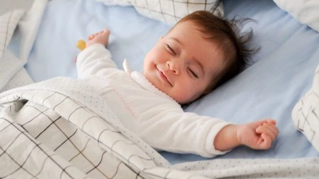 Smiling baby lying on a bed