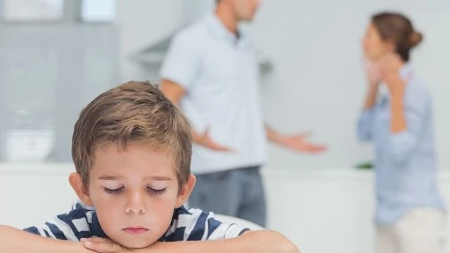 Child caught in the middle of parental conflict—his silence speaks volumes. Co-parenting peace is key to a child's emotional well-being.