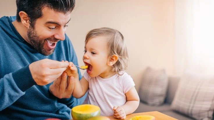Dad feeding baby