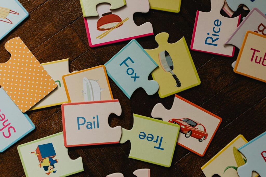 Brightly colored educational puzzle pieces featuring words and images laid on a hardwood floor.